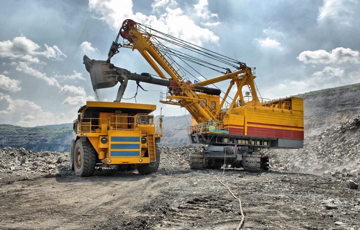 An excavator loading a dump truck in an open-pit mine.